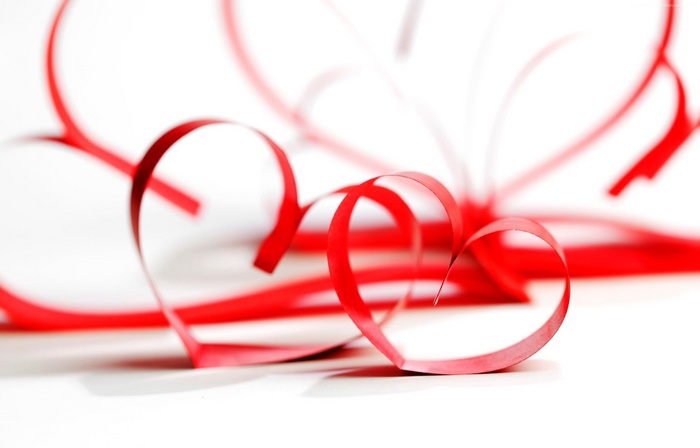 Red ribbon hearts on white background
