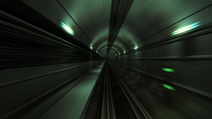 Motion blur in a dark subway tunnel with green lights