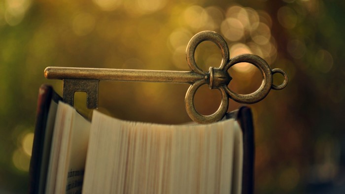Antique key resting on an open book