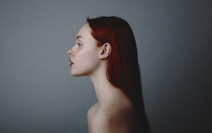 Redhead woman in profile with dark lipstick