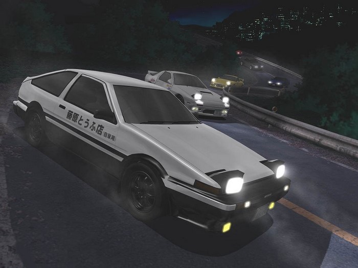 Cars racing on a mountain road at night