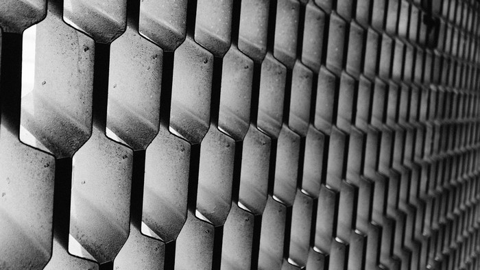 Monochrome close-up of a metal honeycomb pattern