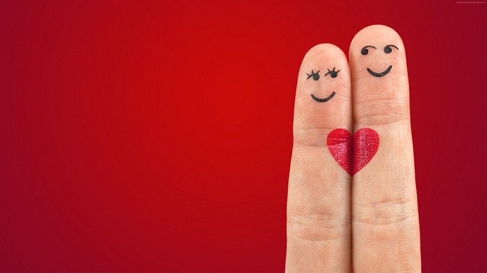 Two fingers with drawn faces and a heart
