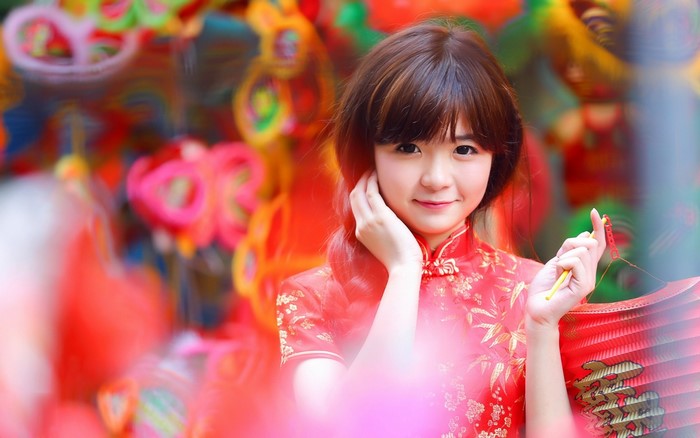 Young Asian woman in traditional red dress holding a lantern