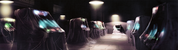 Arcade cabinets covered in sheets with glowing screens