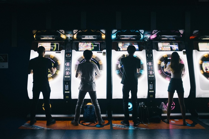 People playing rhythm arcade games