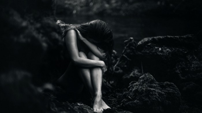 Woman sitting in darkness