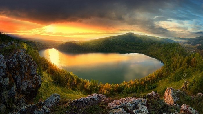 Lake reflection at sunset with mountains and forest