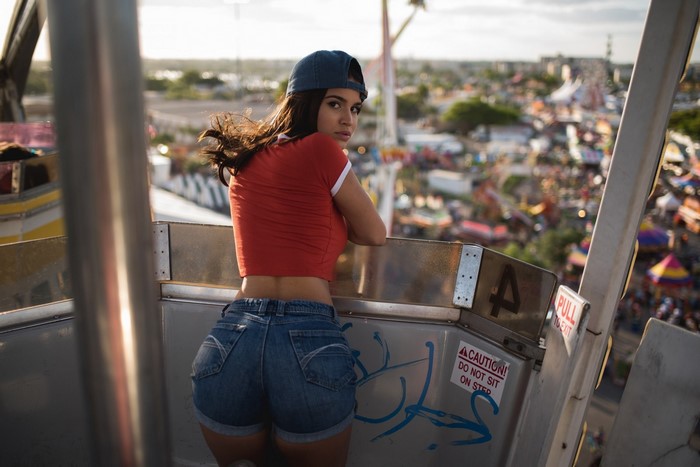Woman in jean shorts and red t-shirt on Ferris wheel