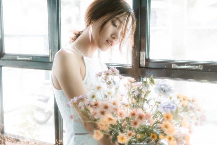 Woman in white dress holding a bouquet of flowers