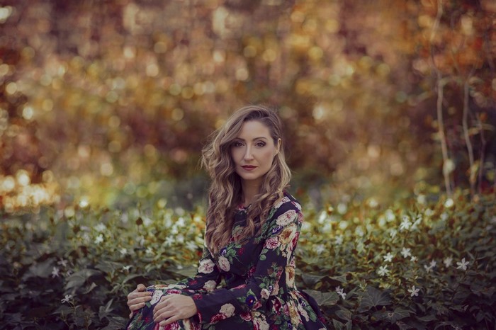 Woman in floral dress sitting in a garden
