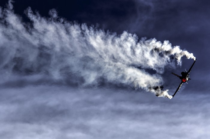 F-16 Fighting Falcon performing aerobatics with smoke trails