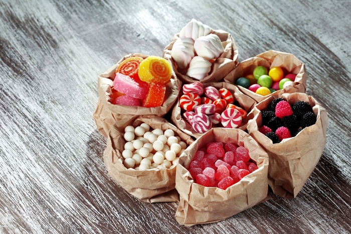 Assortment of colorful candies and marshmallows in paper bags