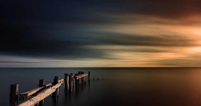 Wooden pier over the sea at sunset