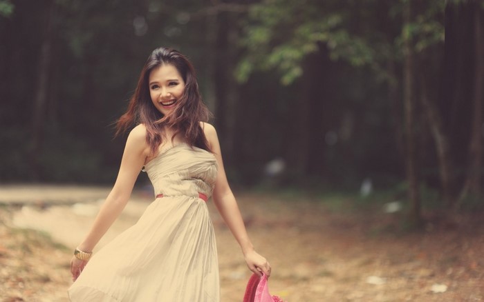Smiling Woman in Beige Dress Outdoors