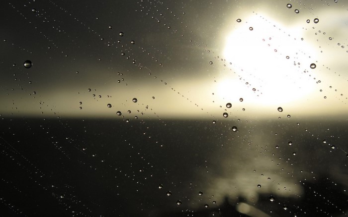 Water drops on glass with sun and sea