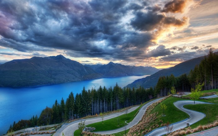 Winding road overlooking a blue lake and mountains