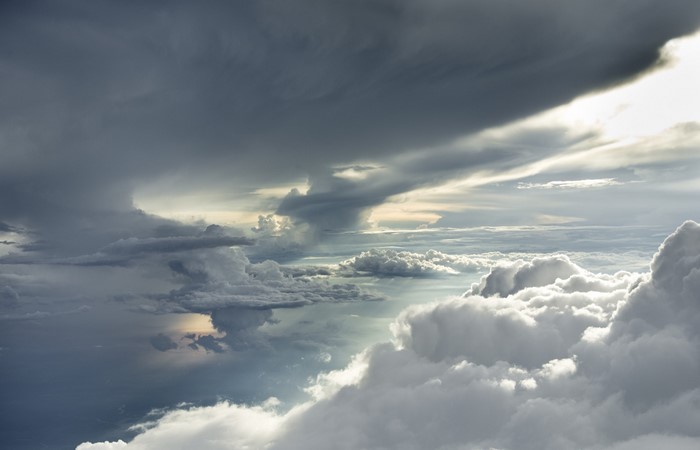 Dramatic storm clouds illuminated by sunlight from above