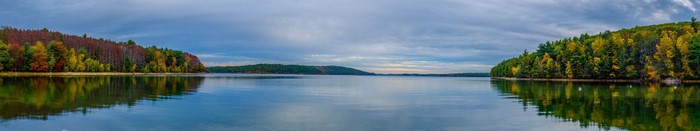 Panoramic autumn landscape of a lake with colorful trees