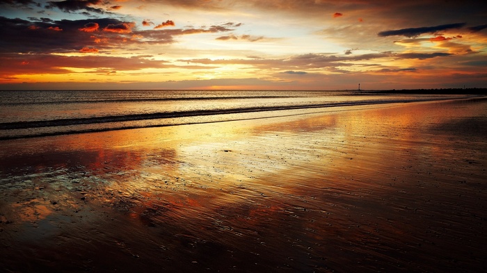 Beach at sunset with reflections