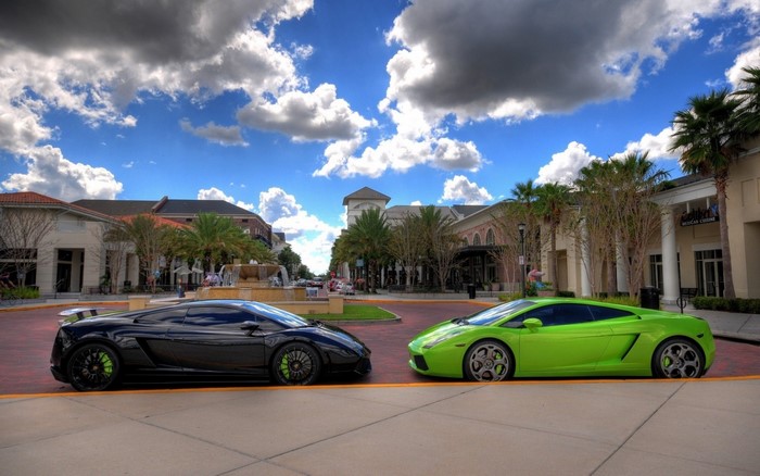 Two Lamborghinis parked in front of a shopping center