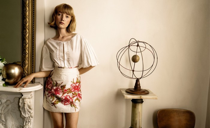 Woman in embroidered skirt and white top