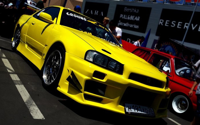 Yellow Nissan Skyline GT-R R34 at a car show