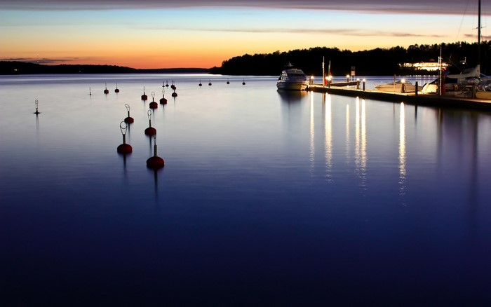 Boats and buoys on a lake at sunset