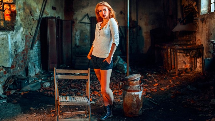 Woman in abandoned building with milk can