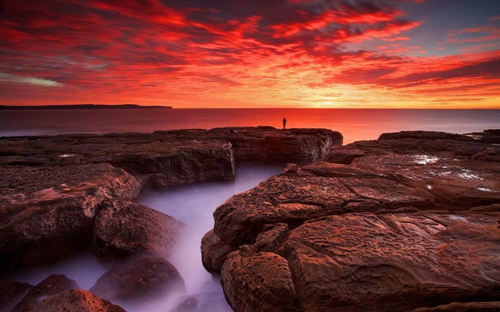 Fiery Red Sunset Over Rocky Coastline