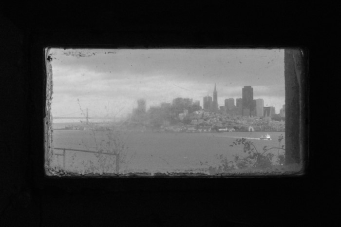 San Francisco cityscape viewed through a dirty window from Alcatraz