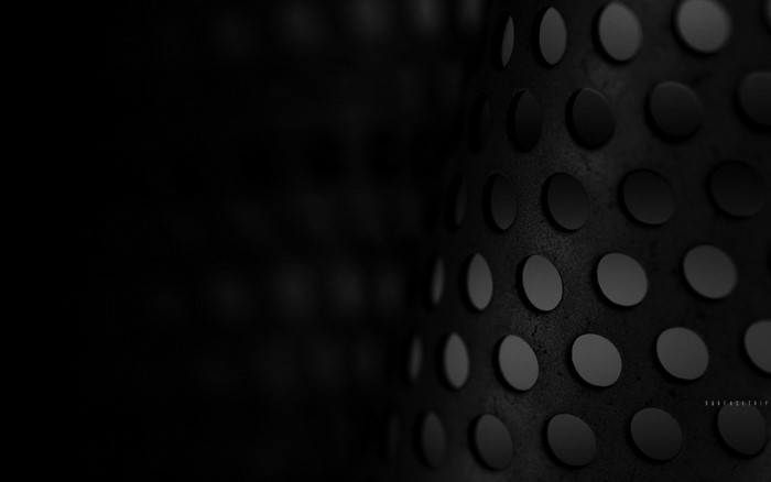 Monochrome close-up of a perforated metal surface
