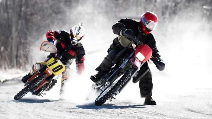 Two motorcyclists racing on a snowy track