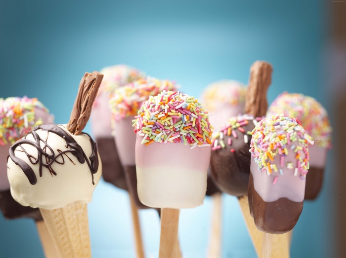 Assorted cake pops with sprinkles and chocolate drizzle