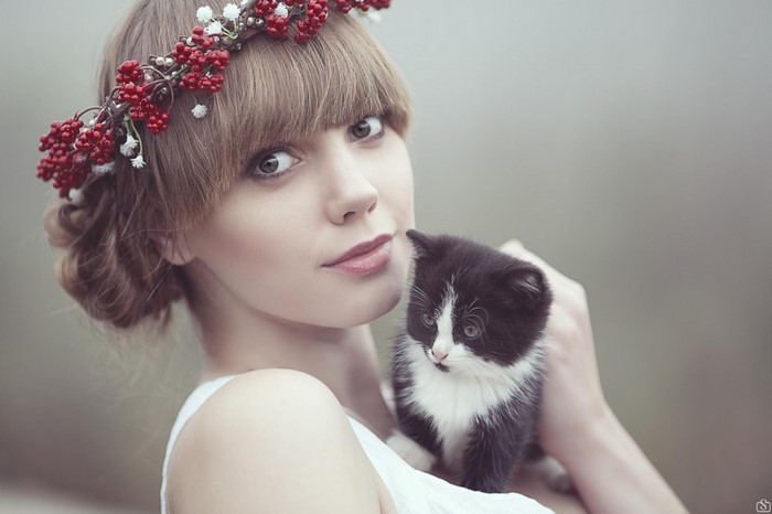 Woman wearing a flower crown holding a kitten
