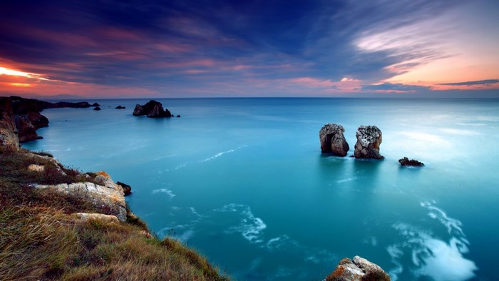 Sunset over the ocean with rocky coast and sea stacks