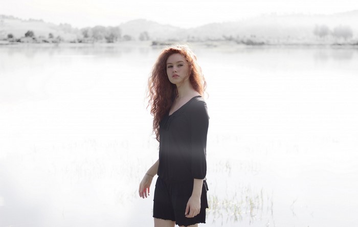 Woman with red hair by a lake