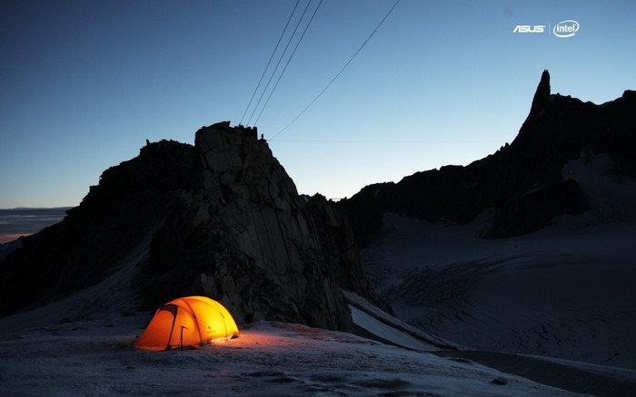 Tent on a snowy mountain at dusk with ASUS and Intel logos