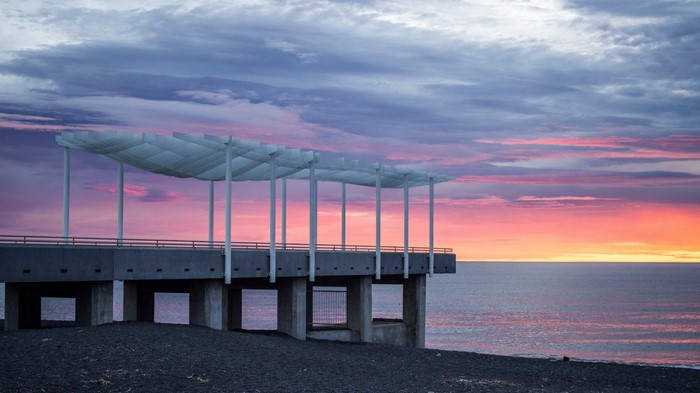 Modern pier structure at sunset over the ocean