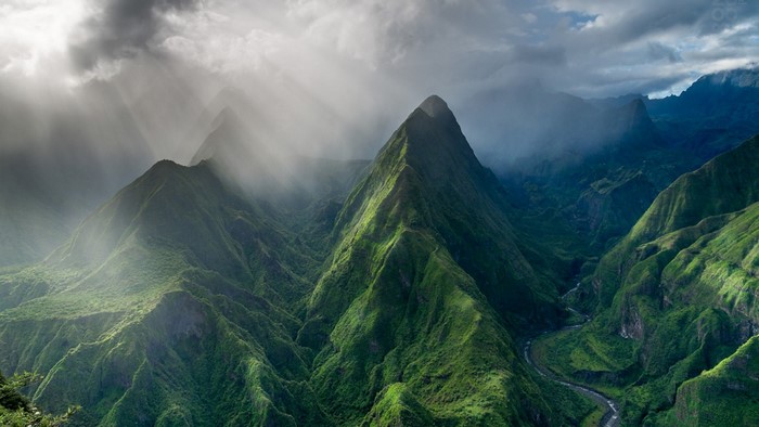 Sunlight Filtering Through Misty Mountain Peaks
