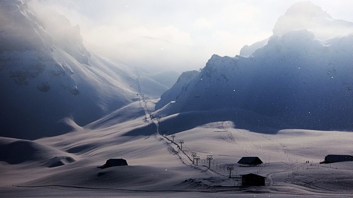 Snowy mountains with ski lifts and houses
