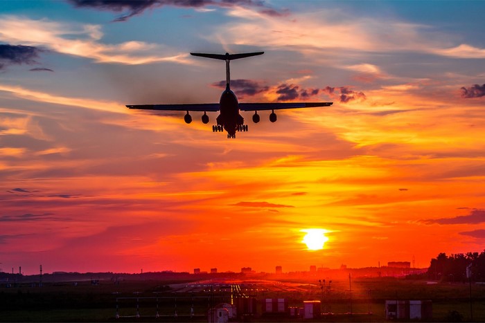 Airplane landing at sunset