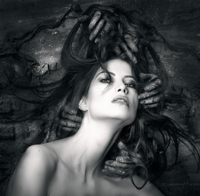 Monochrome portrait of a woman with hands in her hair