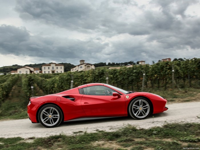 Red Ferrari 488 GTB driving through vineyards