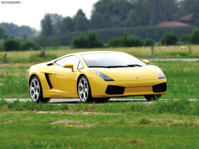 Yellow Lamborghini Gallardo driving on a road