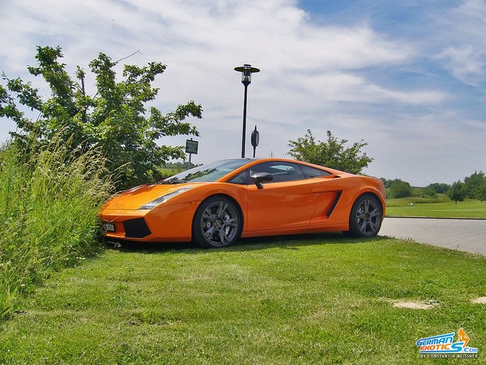 Orange Lamborghini Gallardo parked on grass