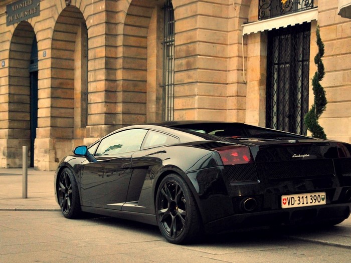Black Lamborghini Gallardo parked in front of a building