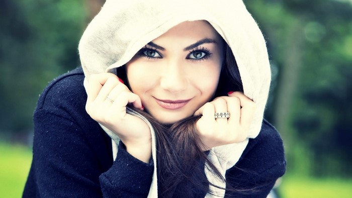 Woman with hood and rings looking at viewer