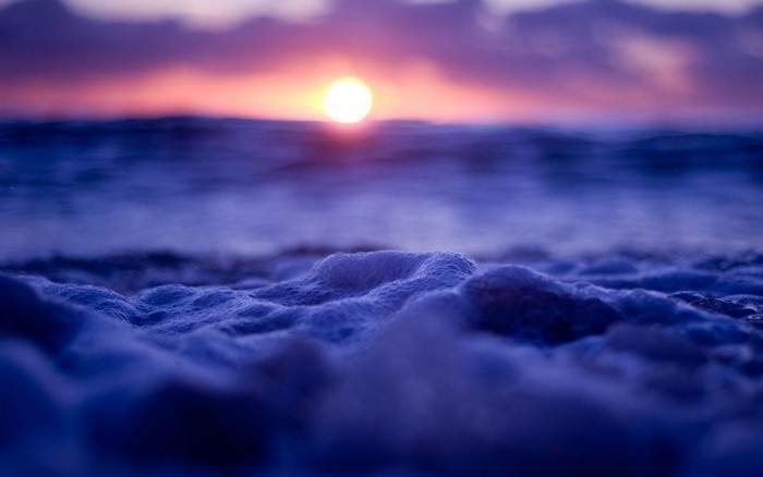 Sunset over the ocean with sea foam