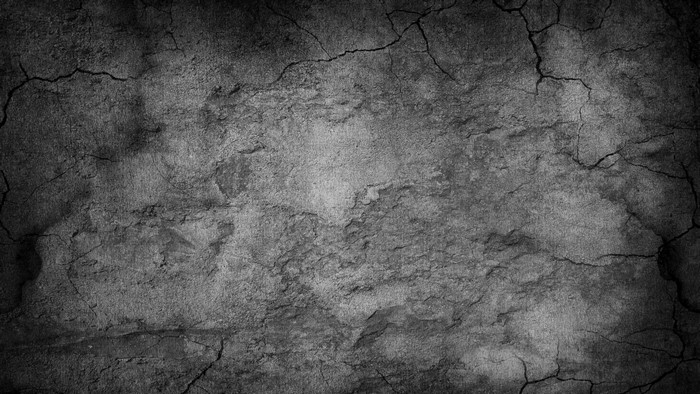 Cracked concrete wall texture with dark shadows